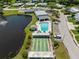 Aerial view showcases a pool, shuffleboard, and pond, providing a view of community amenities at 2212 Lark W Cir # E, Palm Harbor, FL 34684