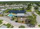 Aerial view of the community center featuring a pool, pond with fountain and ample parking at 2212 Lark W Cir # E, Palm Harbor, FL 34684