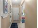 Hallway featuring tiled floors and neutral colored walls with decor, leading to front door at 2212 Lark W Cir # E, Palm Harbor, FL 34684