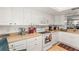 Well-lit kitchen featuring white cabinets, appliances, and ample counter space at 2212 Lark W Cir # E, Palm Harbor, FL 34684