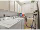 Bright laundry room featuring a washer, dryer, storage cabinets, and sink at 2212 Lark W Cir # E, Palm Harbor, FL 34684