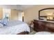 Bright main bedroom featuring a ceiling fan, dresser with mirror, and patterned comforter set at 2212 Lark W Cir # E, Palm Harbor, FL 34684