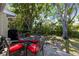 Outdoor patio with a table and chairs surrounded by a lush, landscaped backyard at 2212 Lark W Cir # E, Palm Harbor, FL 34684