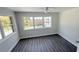 Bright bedroom featuring gray plank flooring, a ceiling fan, and natural light from multiple windows at 2288 Cheryl Rd, Largo, FL 33771
