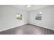A bright bedroom features wood-look flooring, light gray walls, and natural light from dual windows at 2288 Cheryl Rd, Largo, FL 33771
