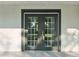 Close-up of the elegant double front doors featuring glass panes and sleek black frames for a modern entryway at 2288 Cheryl Rd, Largo, FL 33771