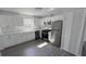 Modern kitchen with white cabinets, stainless steel appliances, and gray wood-look floors at 2288 Cheryl Rd, Largo, FL 33771