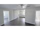 Open-concept living space with new gray flooring and a glimpse into the white kitchen and bathroom at 2288 Cheryl Rd, Largo, FL 33771