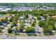 Aerial view showcases a home in a neighborhood with mature trees, in close proximity to retail and businesses at 2486 Hickman Cir, Clearwater, FL 33761