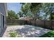 Back yard features brick patio, mature tree, and wooden fence for privacy and relaxation at 2486 Hickman Cir, Clearwater, FL 33761