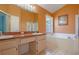 Bathroom featuring double sinks, bathtub, shower and large window at 2486 Hickman Cir, Clearwater, FL 33761