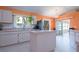 Bright kitchen features an island, stainless steel refrigerator, and an adjacent screened patio at 2486 Hickman Cir, Clearwater, FL 33761