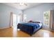 Main bedroom with slider to a sunroom, 2 windows, and wood flooring at 2486 Hickman Cir, Clearwater, FL 33761