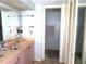 View of the bathroom with vanity, mirror, towel rack, and open door to the shower with a tile surround at 2618 Cove Cay Dr # 403, Clearwater, FL 33760