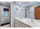 Serene bathroom featuring dual sinks, a door to the backyard, and light blue walls at 2932 Chelsea Woods Dr, Valrico, FL 33596