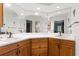 Bright bathroom features a large mirror, dual sinks, and wood cabinetry at 2932 Chelsea Woods Dr, Valrico, FL 33596