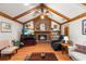 Inviting living room with a classic brick fireplace, beamed vaulted ceilings, and comfortable seating at 2932 Chelsea Woods Dr, Valrico, FL 33596