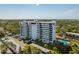 Breathtaking aerial view of the high-rise building, parking, pool, and verdant tree line at 30 Turner St # 604, Clearwater, FL 33756