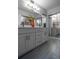 Bathroom featuring a double vanity with quartz countertop, cabinet storage and a large mirror at 30 Turner St # 604, Clearwater, FL 33756