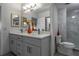 Bathroom featuring a double vanity with quartz countertop, large mirror and tiled shower at 30 Turner St # 604, Clearwater, FL 33756
