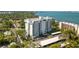 Aerial view of condo building with lush surroundings, showcasing parking and nearby residential areas at 30 Turner St # 604, Clearwater, FL 33756