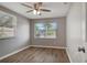 Bedroom with wood-look flooring, ceiling fan, and a bright window overlooking the street at 3003 E 27Th Ave, Tampa, FL 33605