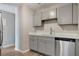 Updated kitchen features modern cabinets, stainless steel dishwasher, and white quartz countertops at 3003 E 27Th Ave, Tampa, FL 33605