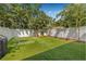 A backyard featuring artificial turf, a putting green, Adirondack chairs, and lush tropical landscaping at 307 S Gomez Ave # 1, Tampa, FL 33609