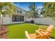 A well-manicured backyard with artificial turf, putting green, and mature tropical trees at 307 S Gomez Ave # 1, Tampa, FL 33609
