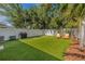 Artificial turf putting green with Adirondack chairs in landscaped backyard at 307 S Gomez Ave # 1, Tampa, FL 33609