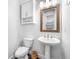 Elegant powder room featuring a pedestal sink, wood-framed mirror, and decorative accents at 307 S Gomez Ave # 1, Tampa, FL 33609