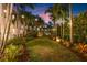 Idyllic backyard featuring a manicured lawn, mature landscaping, and soft string lighting at 356 22Nd Ne Ave, St Petersburg, FL 33704