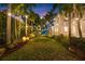 Serene backyard featuring a lush lawn, palm trees, and charming string lights at twilight at 356 22Nd Ne Ave, St Petersburg, FL 33704
