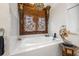 A well-lit bathroom featuring a soaking tub with a beautifully carved wooden frame and elegant fixtures at 356 22Nd Ne Ave, St Petersburg, FL 33704