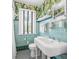 Bright vintage bathroom with tiled walls, a clean white sink, and a patterned floor at 356 22Nd Ne Ave, St Petersburg, FL 33704