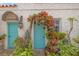 Charming entryway with two turquoise doors, adorned with climbing plants and flowers, creating a welcoming and picturesque entrance at 356 22Nd Ne Ave, St Petersburg, FL 33704