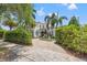 Charming home featuring lush greenery, manicured hedges, and a textured paver driveway at 356 22Nd Ne Ave, St Petersburg, FL 33704