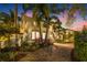 Twilight shot of landscaped exterior with paved driveway and mature palm trees at 356 22Nd Ne Ave, St Petersburg, FL 33704