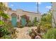 Exterior view showcasing a beautiful garden, fountain, and turquoise doors, enhancing the curb appeal and creating a serene ambiance at 356 22Nd Ne Ave, St Petersburg, FL 33704