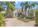 Beautiful home showcasing a stucco facade, lush landscaping, and a circular paver driveway at 356 22Nd Ne Ave, St Petersburg, FL 33704