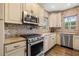 Well-lit kitchen features stainless steel appliances, granite countertops, custom cabinets and a unique backsplash at 356 22Nd Ne Ave, St Petersburg, FL 33704