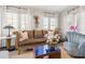Cozy living room with an ornate sofa, white curtains, and a decorative wall hanging at 356 22Nd Ne Ave, St Petersburg, FL 33704