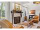 A well-lit living room featuring a fireplace, comfortable armchair, and large windows at 356 22Nd Ne Ave, St Petersburg, FL 33704