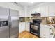Modern kitchen with stainless steel appliances, granite countertops, and white cabinetry for a clean look at 3709 W Santiago St, Tampa, FL 33629