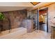 Bathroom with shower, soaking tub, stone tile, and doorway into an adjacent room at 3931 Pompano Se Dr, St Petersburg, FL 33705