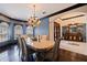 Dining room with chandelier, wood floors, large windows, and a view to the front entryway with tile floors at 3931 Pompano Se Dr, St Petersburg, FL 33705