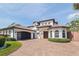 Stunning two-story home with a terracotta tile roof, brick driveway, and beautiful landscaping at 3931 Pompano Se Dr, St Petersburg, FL 33705