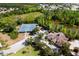 Aerial view of a community clubhouse, tennis courts, pool and pond surrounded by mature trees in a residential community at 4105 Waterville Ave, Wesley Chapel, FL 33543