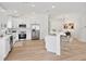 Modern kitchen boasts white cabinets, stainless steel appliances, and a center island with bar seating at 4105 Waterville Ave, Wesley Chapel, FL 33543