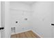 Bright laundry room with wood floors, utility hookups and a hanging rack for drying clothes at 4105 Waterville Ave, Wesley Chapel, FL 33543